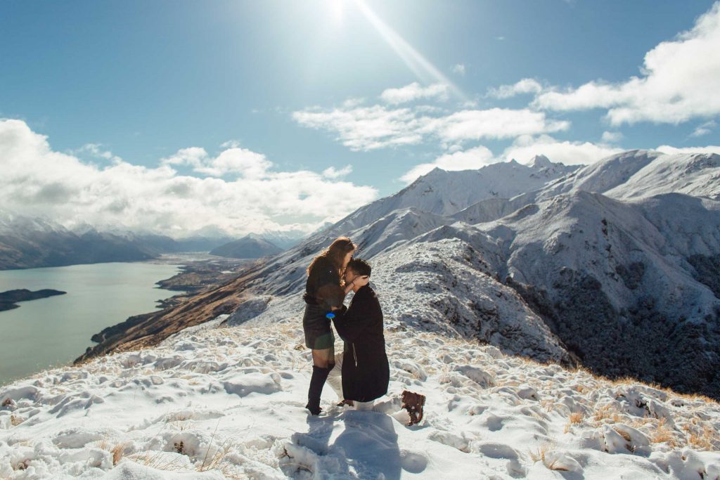Guy proposing on mountain top