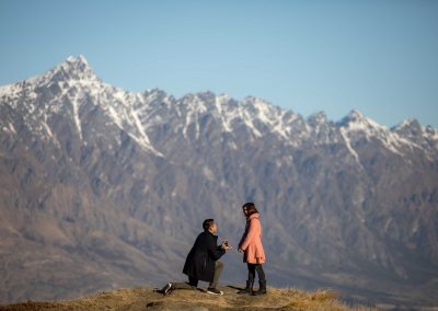 Guy proposing to girl on mountain top