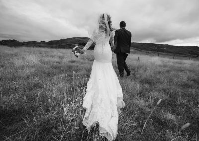 bride and groom walking over field