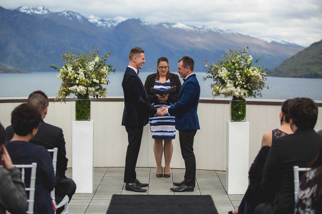Groom's holding hand with celebrant behind