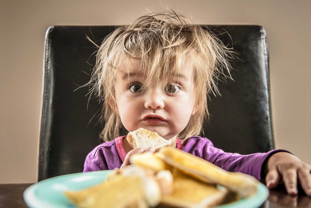portrait of young girl eating toast