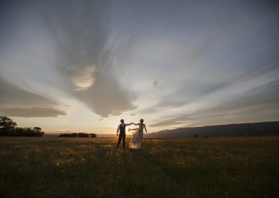 Queenstown weddbride and groom hold hands in sunset