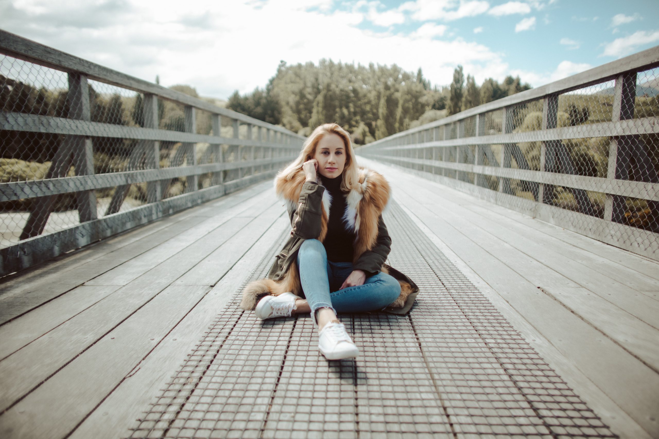 woman sitting on bridge