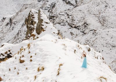 woman standing in snow in blue dress