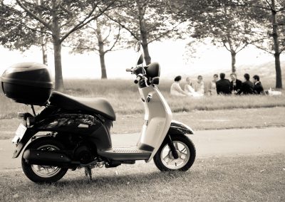Vespa in foreground wedding party behind