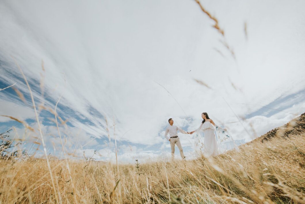 couple holding hands in field