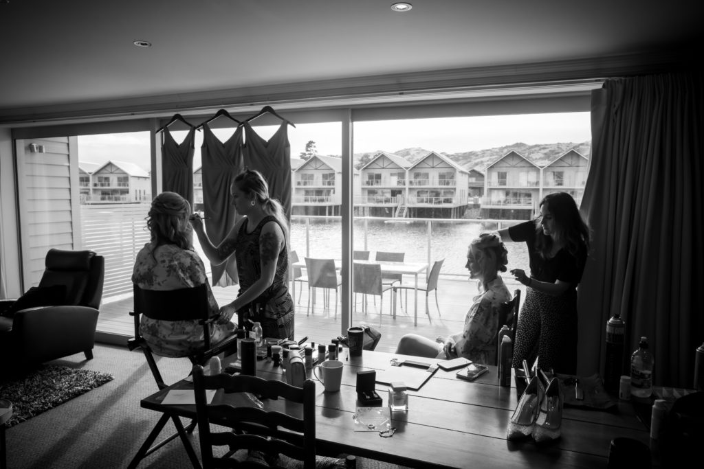 Bride and bridesmaid getting hair and make up done.