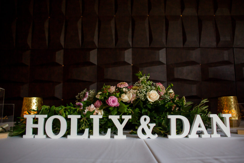 Sign saying 'HOLLY & DAN' plus flowers