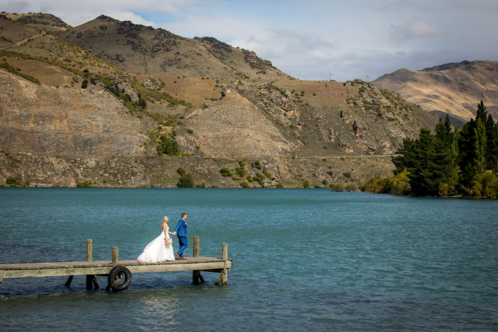 Bride and groom on pier over lake Dunston