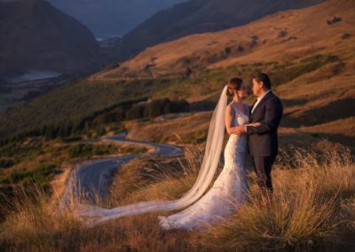 Bride and groom in field at sunrise