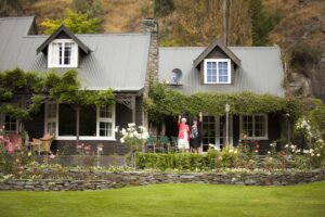 two woman waving outside of a house