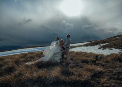 bride and groom with celebrant on mountain
