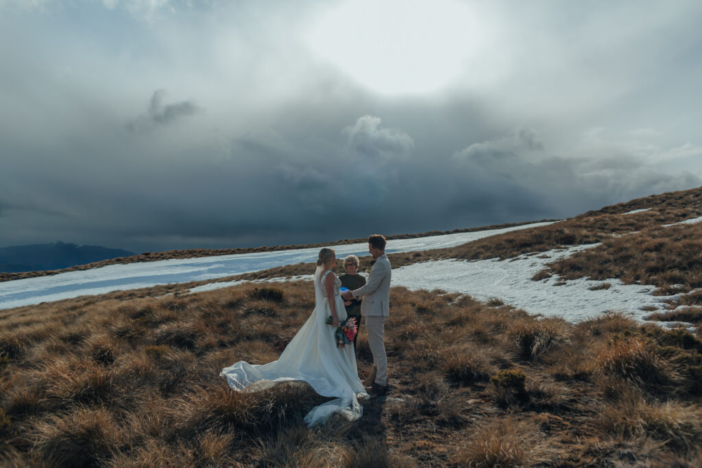 bride and groom on mountain with celebrant