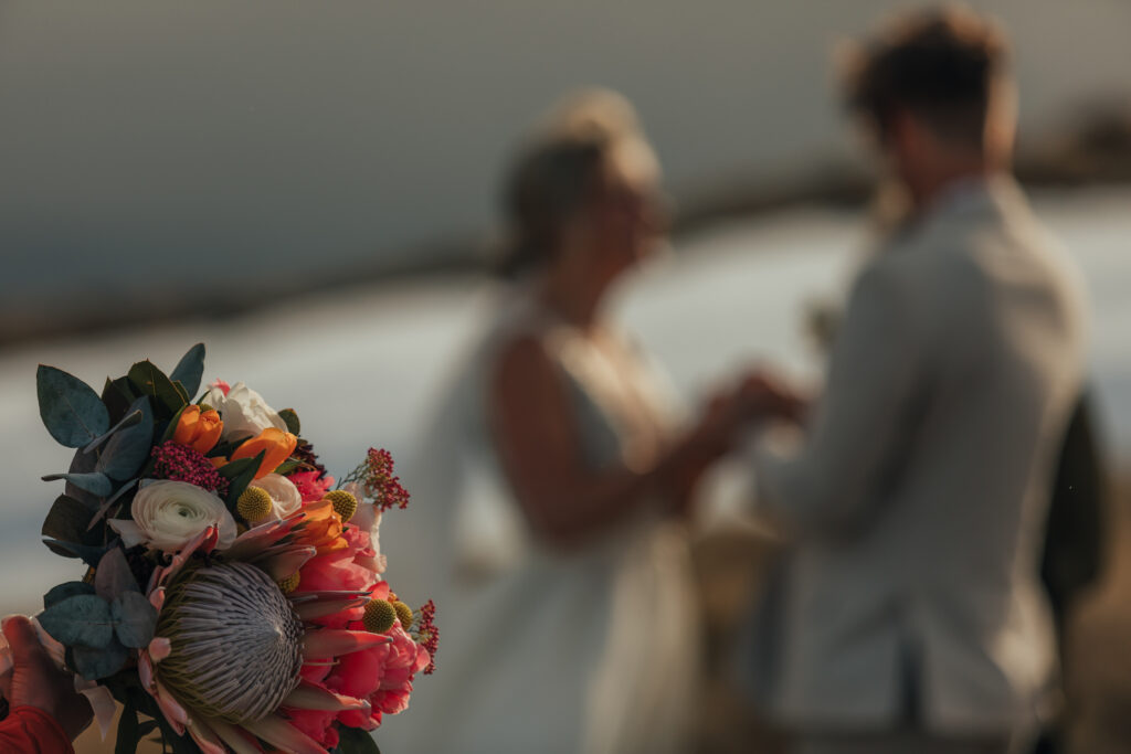 focus on flowers, and blurred bride and groom