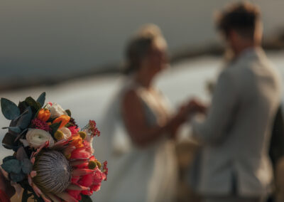 focus on flowers, and blurred bride and groom