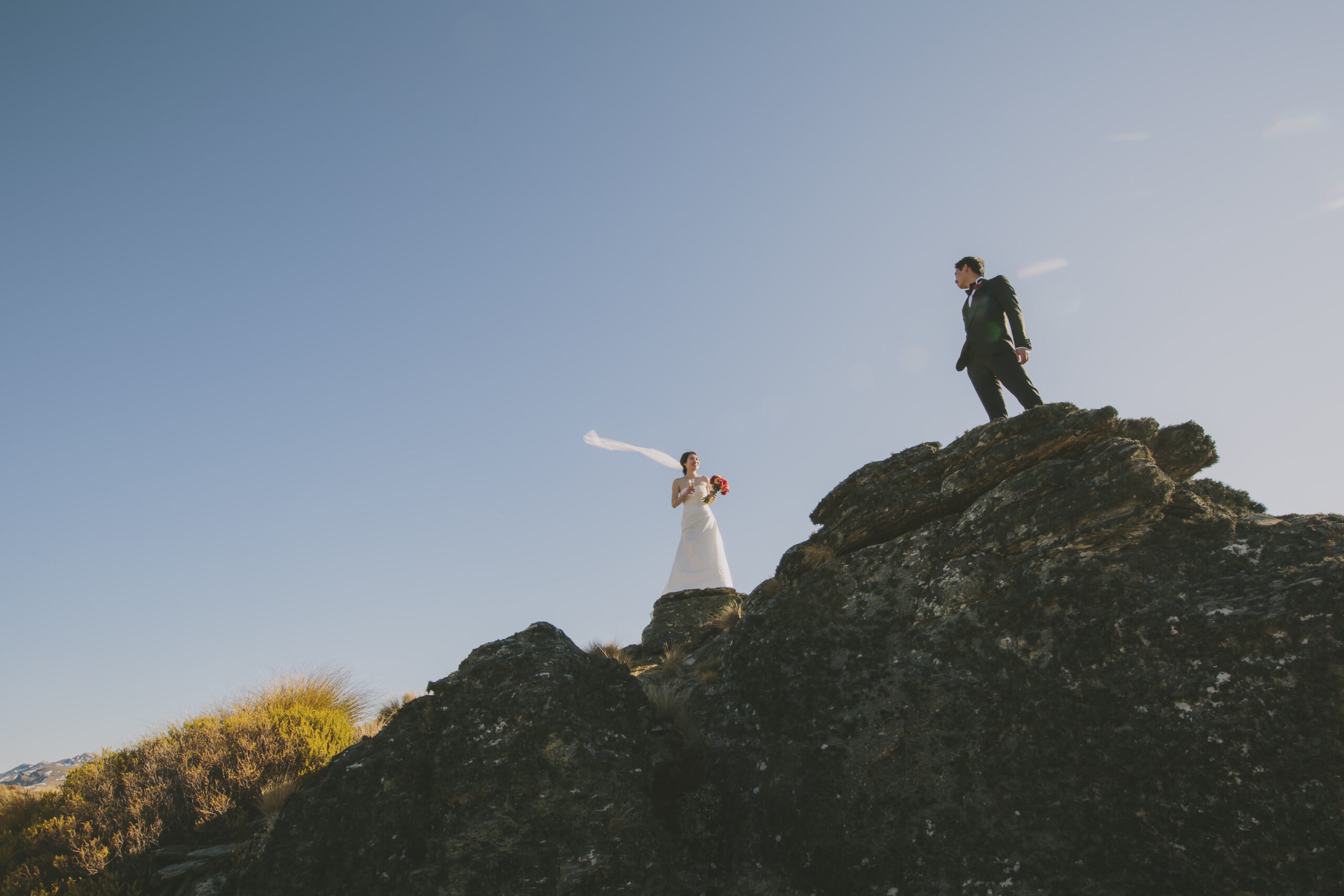 Bride and groom standing on rocks