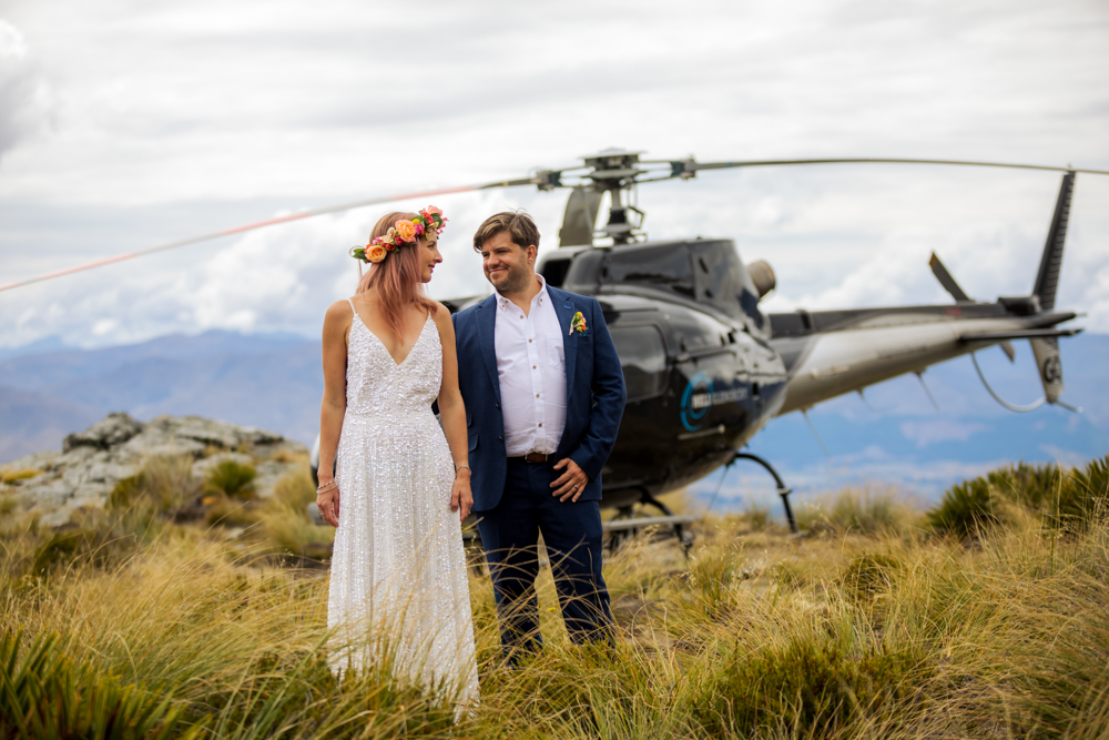 Bride and groom kissing in front of helicopter