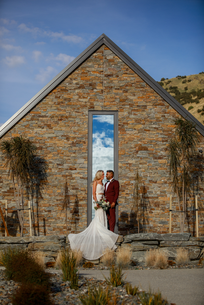 bride and groom in front of building