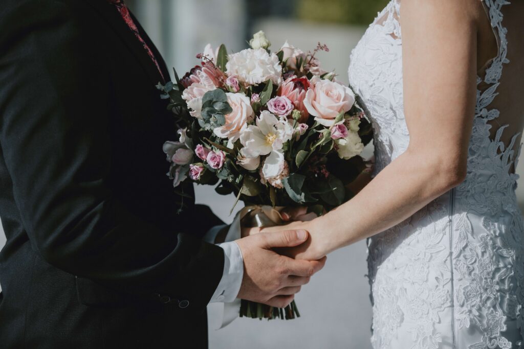 bride and groom holding hands with bouquet